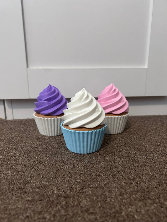 Three 3D printed cupcake topper holders in purple, pink and blue with swirled icing